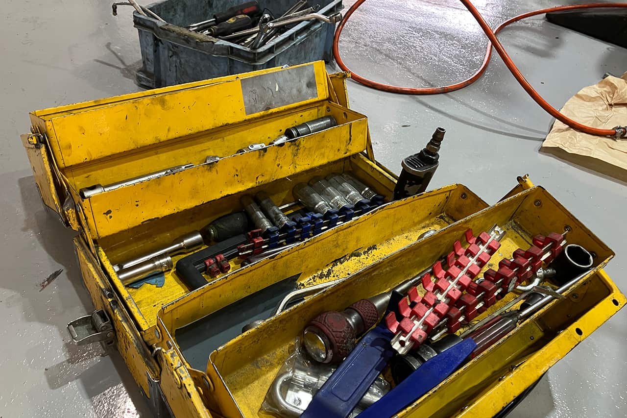 引き出しが開いた黄色い工具箱と多数の工具